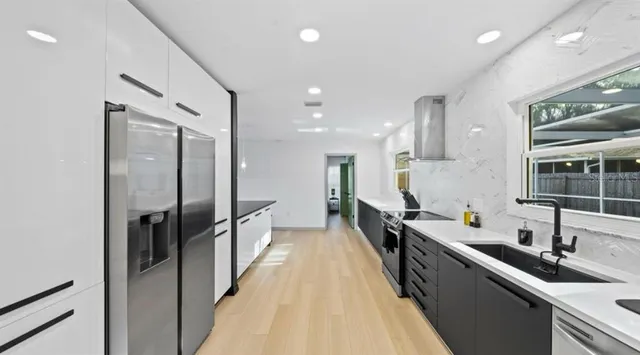 a kitchen with stainless steel appliances a sink stove and refrigerator