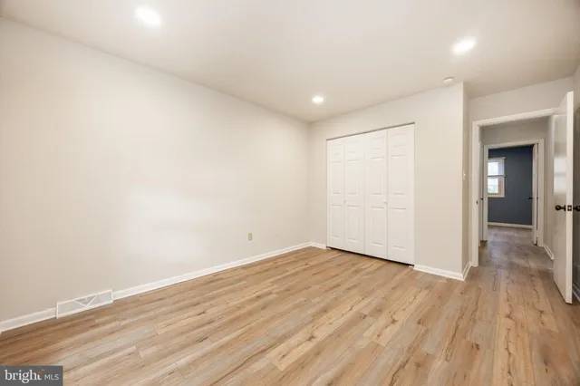 a view of empty room with wooden floor