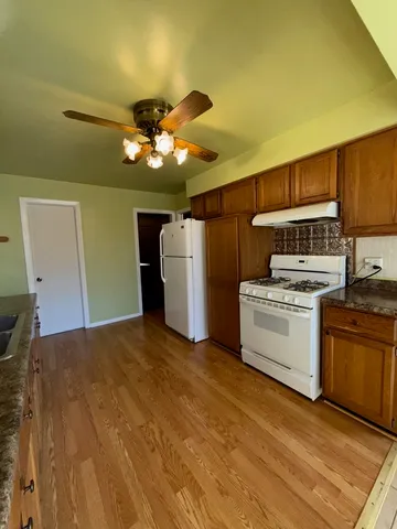 a kitchen with stainless steel appliances granite countertop a sink a stove and refrigerator