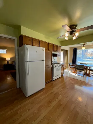 a kitchen with refrigerator and a stove top oven
