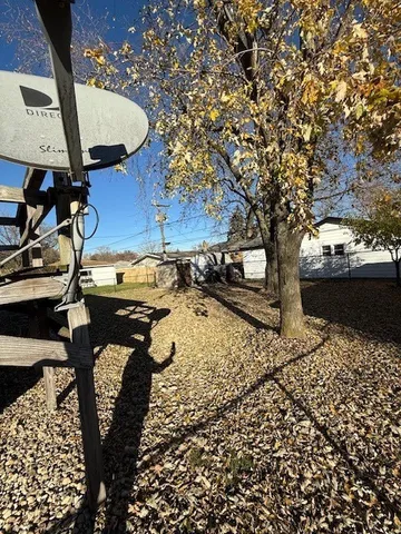 a view of backyard with wooden fence