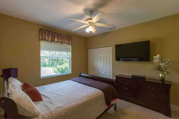 a bedroom with a bed chandelier and a window