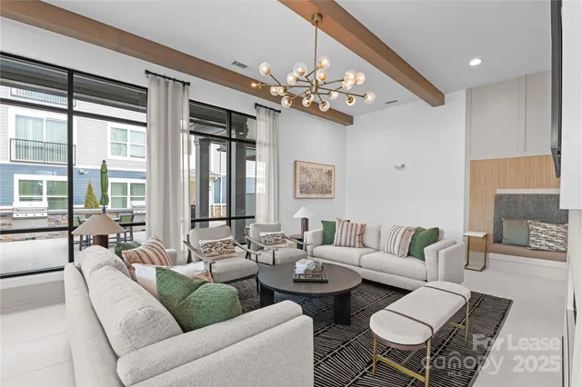 a living room with furniture chandelier and a large window