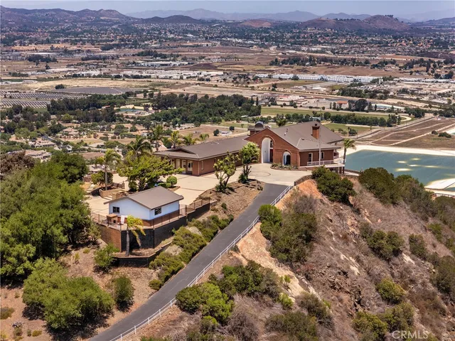 an aerial view of residential houses with outdoor space and trees