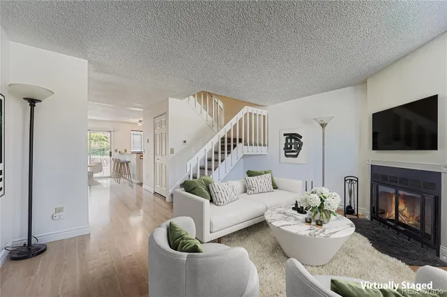 a living room with furniture a flat screen tv and a fireplace