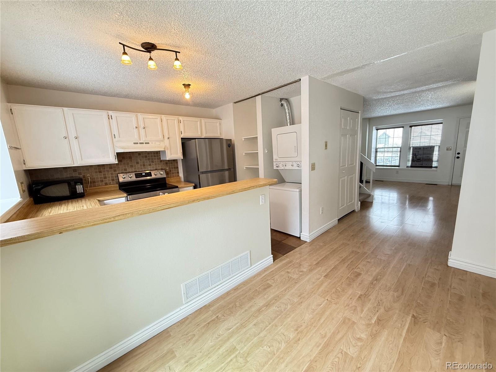 17315 East Rice Circle, Unit G Aurora, CO 80015 - Photo 12 of 31 a kitchen with stainless steel appliances a refrigerator sink and microwave