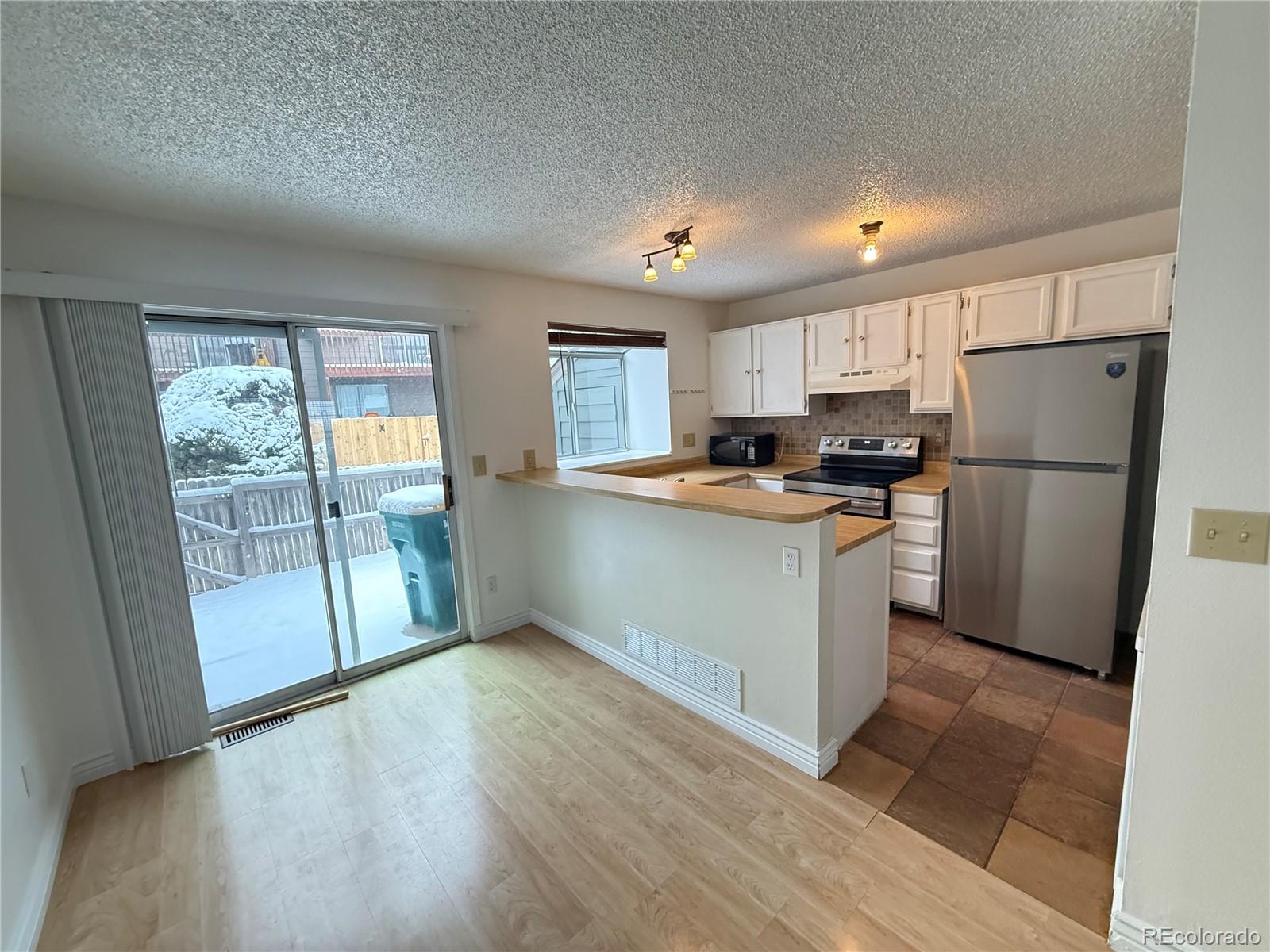 17315 East Rice Circle, Unit G Aurora, CO 80015 - Photo 14 of 31 a kitchen with a refrigerator a stove top oven and a large window
