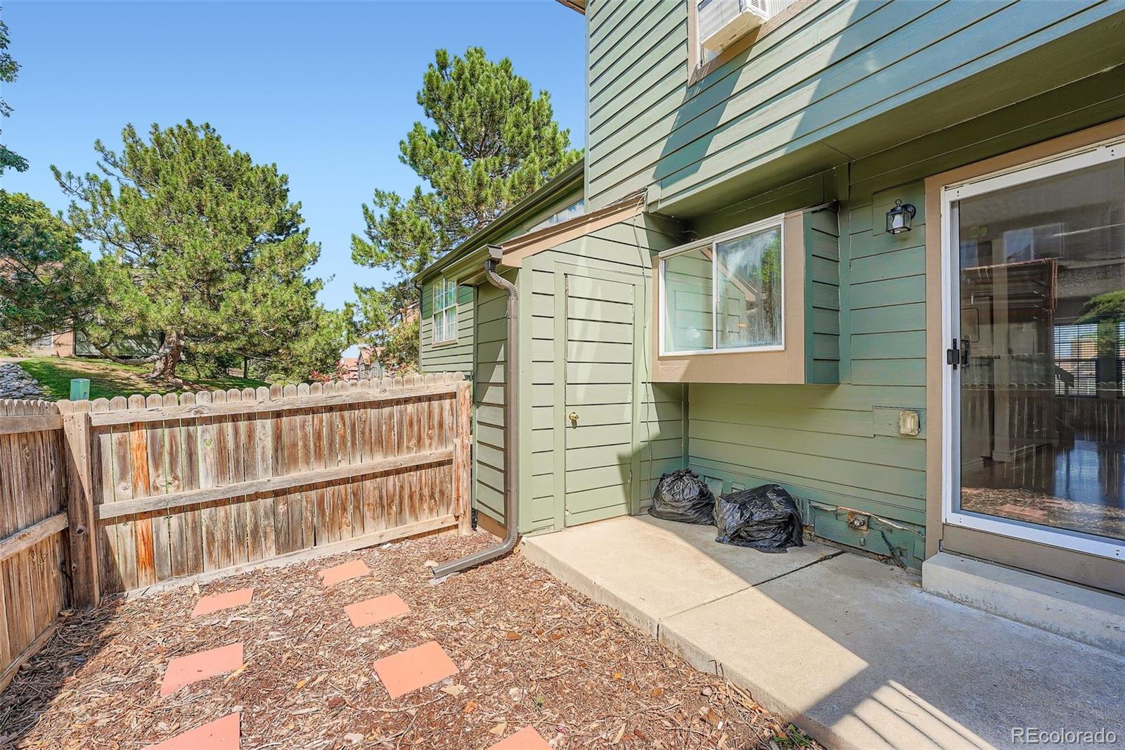 17315 East Rice Circle, Unit G Aurora, CO 80015 - Photo 16 of 31 a view of a backyard with a chair and wooden fence