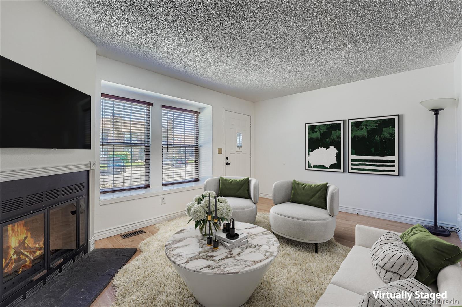 17315 East Rice Circle, Unit G Aurora, CO 80015 - Photo 2 of 31 a living room with furniture a flat screen tv and a fireplace