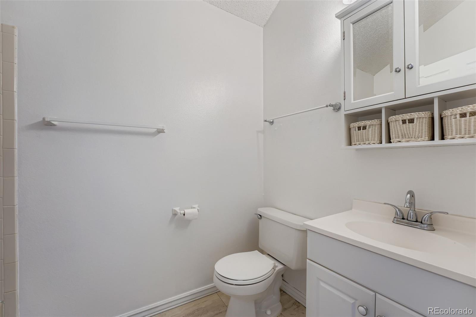 17315 East Rice Circle, Unit G Aurora, CO 80015 - Photo 25 of 31 a white toilet sitting next to a bathroom sink