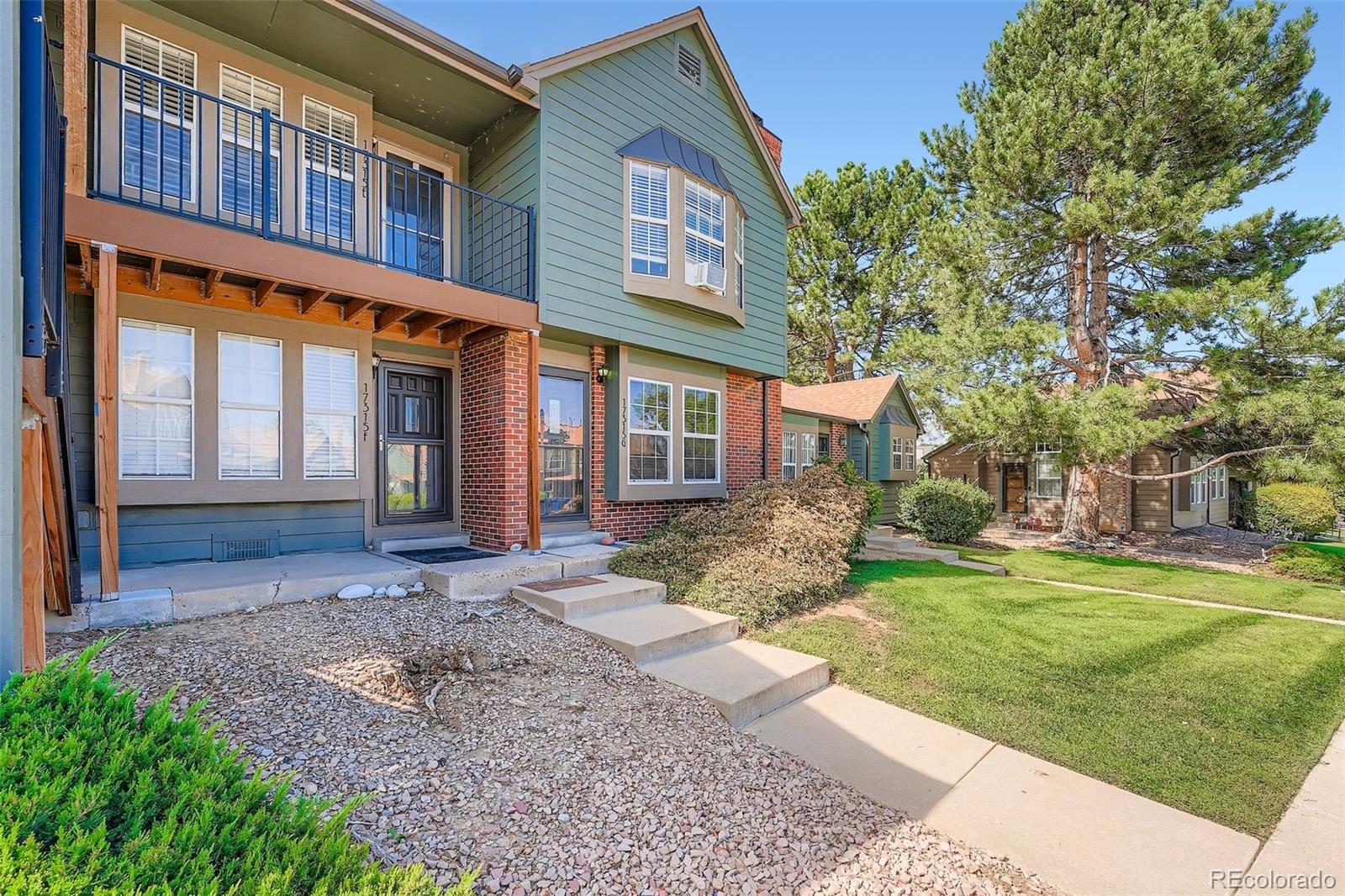 17315 East Rice Circle, Unit G Aurora, CO 80015 - Photo 6 of 31 front view of a brick house with a yard