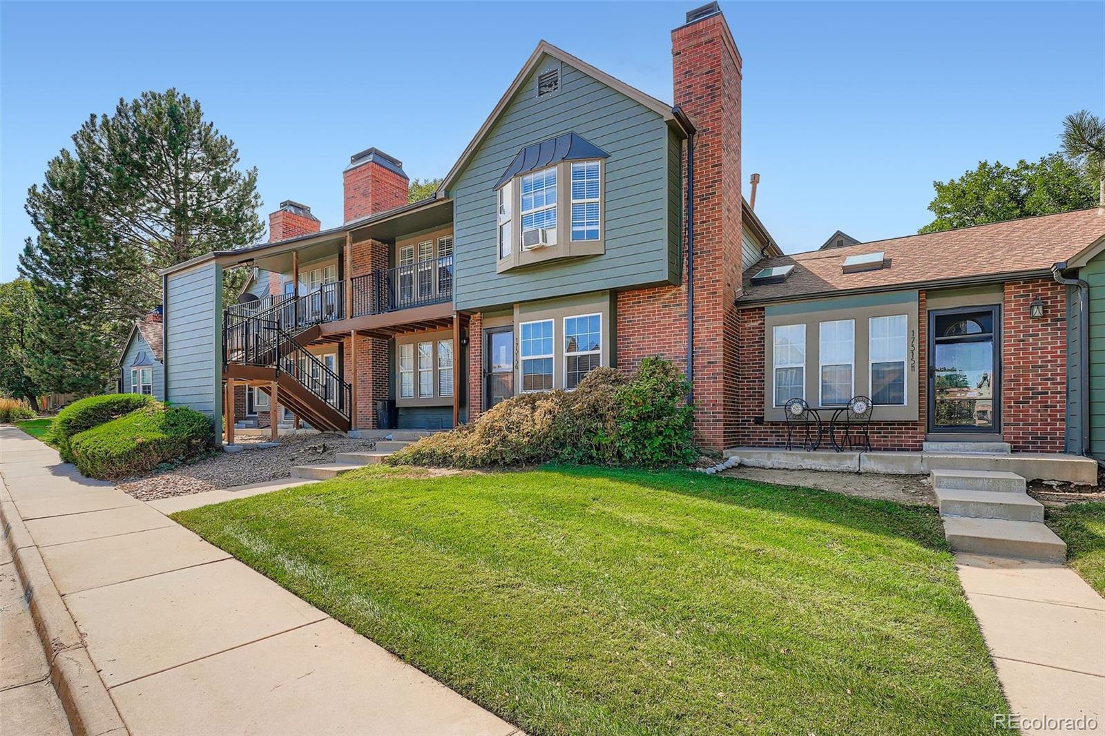 17315 East Rice Circle, Unit G Aurora, CO 80015 - Photo 7 of 31 a front view of a house with a yard and porch