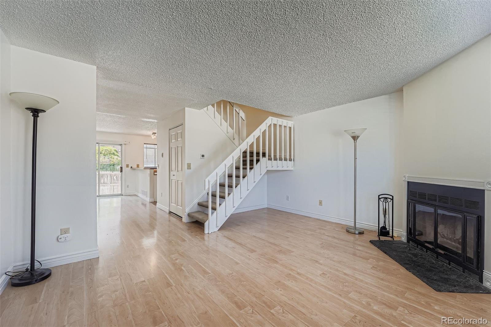 17315 East Rice Circle, Unit G Aurora, CO 80015 - Photo 8 of 31 a view of an empty room with wooden floor fireplace and a window