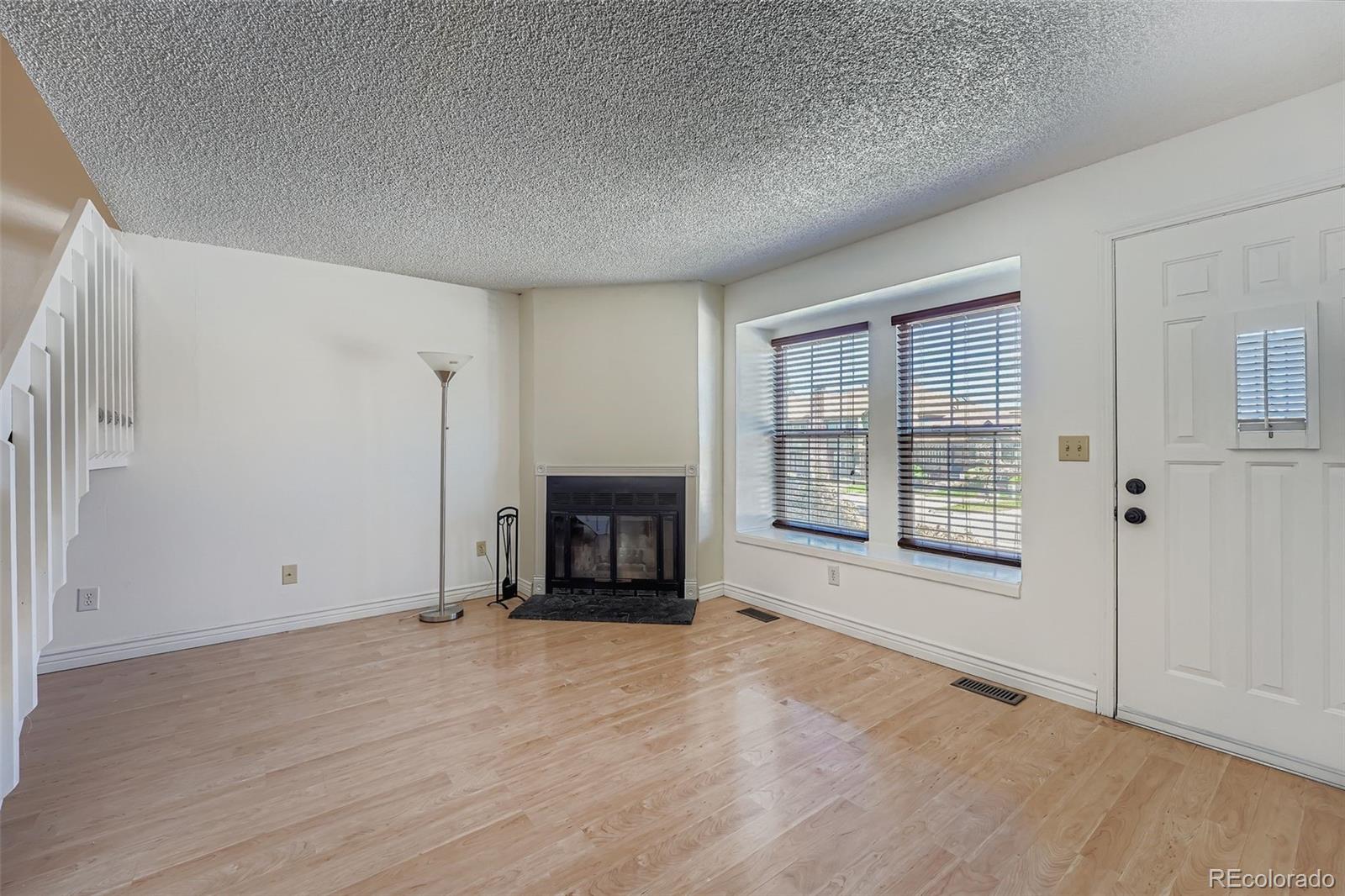 17315 East Rice Circle, Unit G Aurora, CO 80015 - Photo 9 of 31 a view of an empty room with a fireplace and a window
