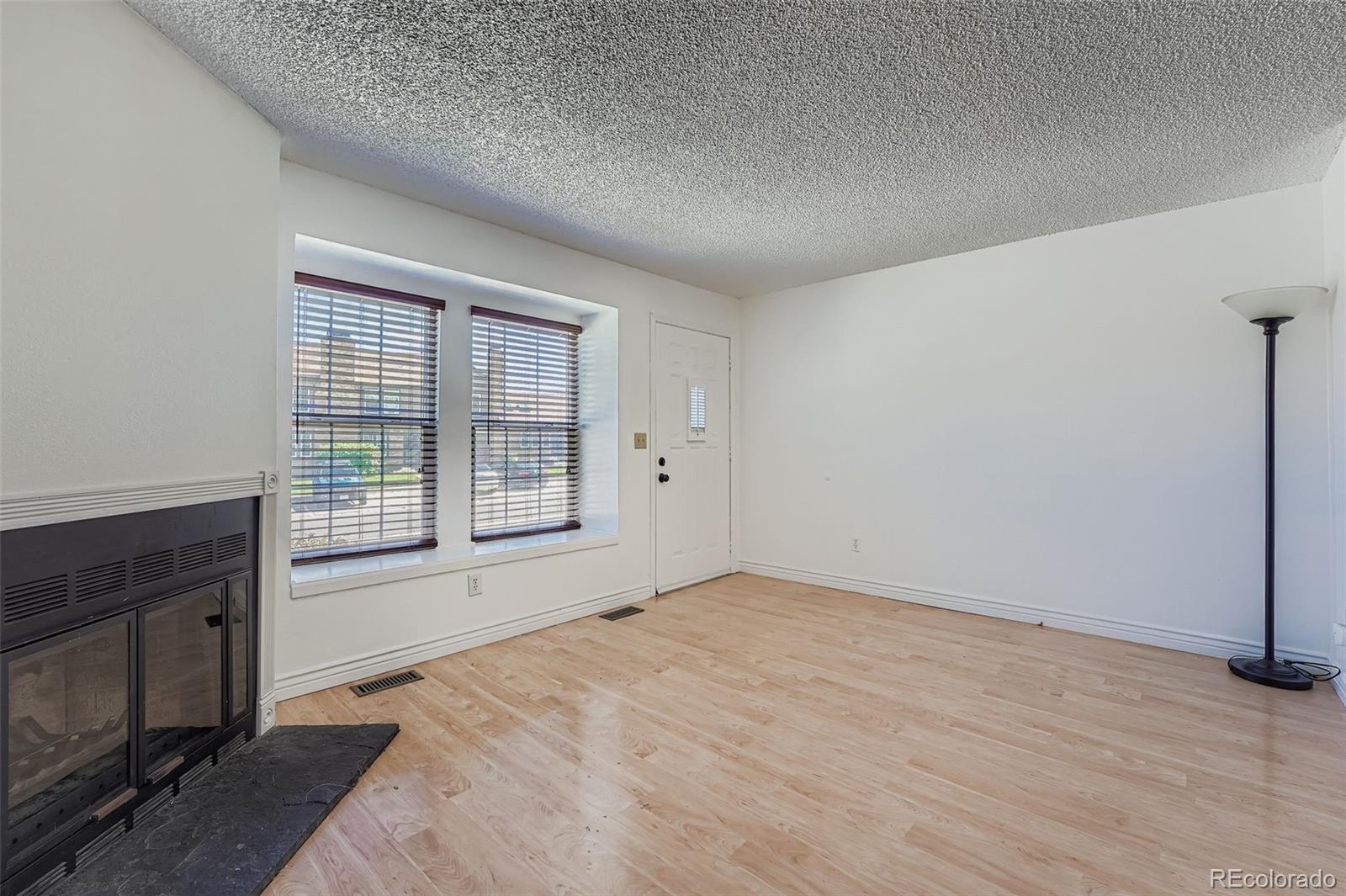 17315 East Rice Circle, Unit G Aurora, CO 80015 - Photo 10 of 31 a view of an empty room with a fireplace and a window