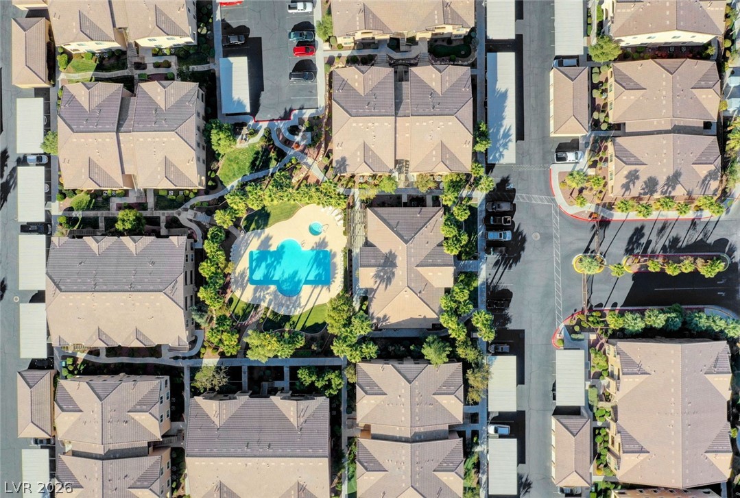 8985 South Durango Drive, Unit 2187 Las Vegas, NV 89113 - Photo 41 of 73 An aerial perspective reveals a vibrant community pool amidst residential structures and well-maintained landscaping.
