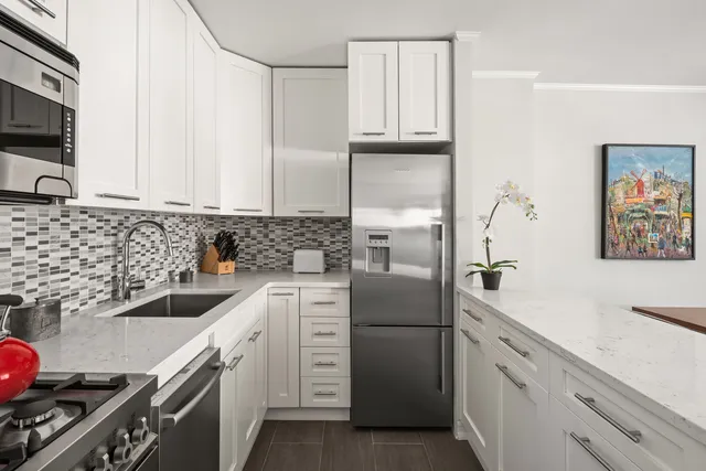 a kitchen with stainless steel appliances a white table and chairs in it