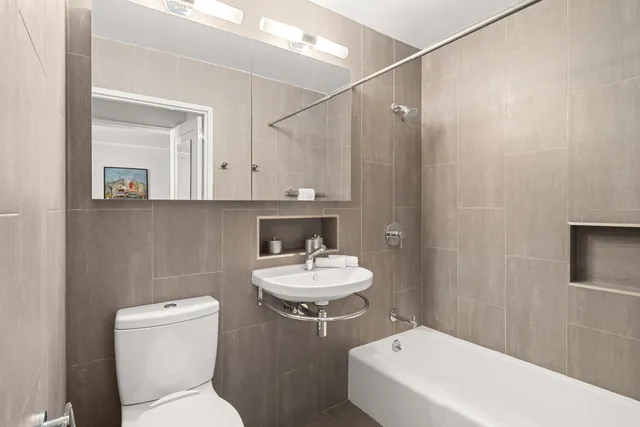 a bedroom with a bed and a dresser next to a window