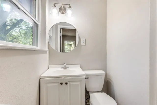 a bathroom with a toilet sink and mirror