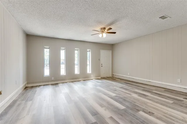 a view of an empty room with glass door and a window