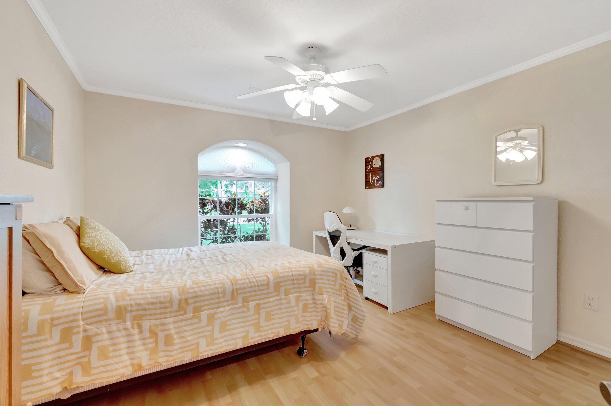 166 Southwest 8th Avenue Boca Raton, FL 33486 - Photo 16 of 25 a bedroom with a bed and a chandelier