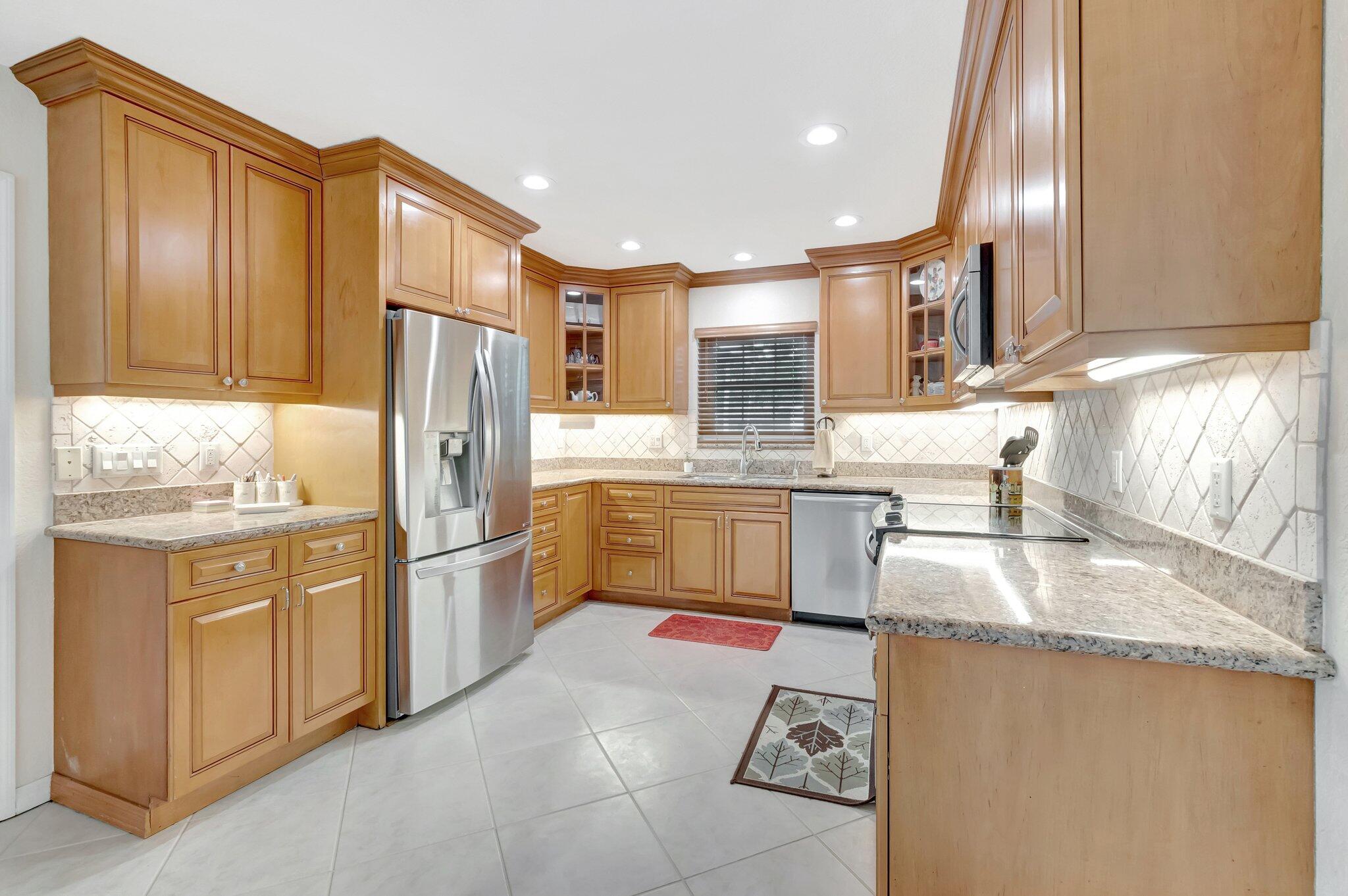 166 Southwest 8th Avenue Boca Raton, FL 33486 - Photo 7 of 25 a kitchen with stainless steel appliances granite countertop a sink refrigerator stove and microwave