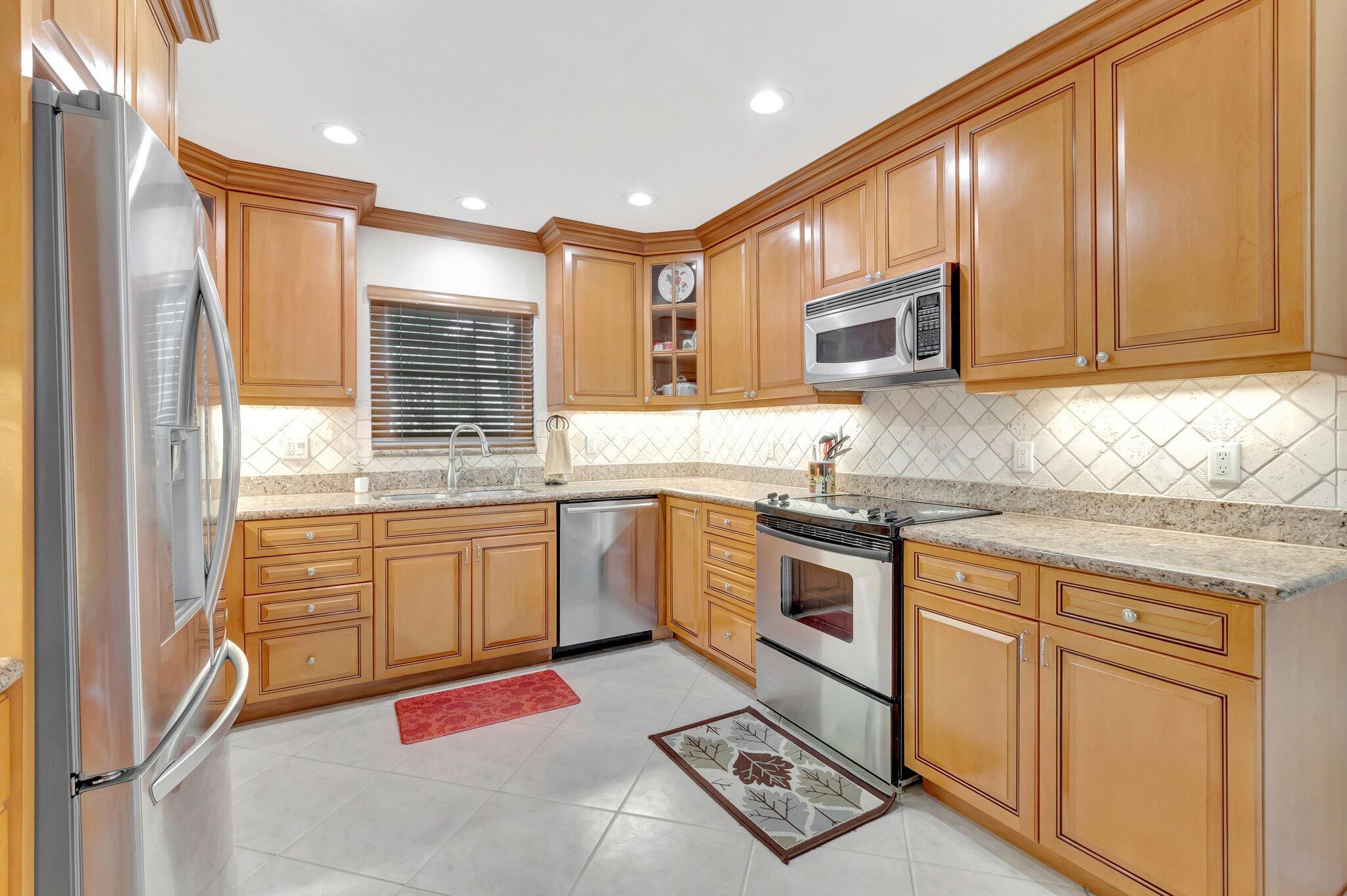 166 Southwest 8th Avenue Boca Raton, FL 33486 - Photo 8 of 25 a kitchen with granite countertop a sink stainless steel appliances and cabinets