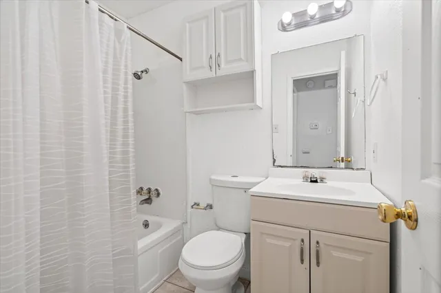 a backyard of a house with plants and trees with wooden fence