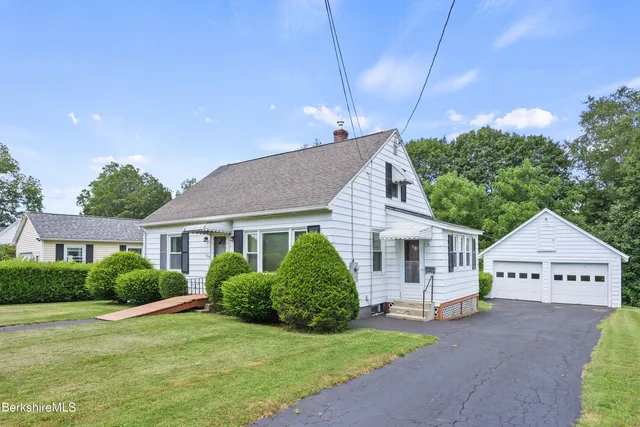 a view of a house with a yard and potted plants