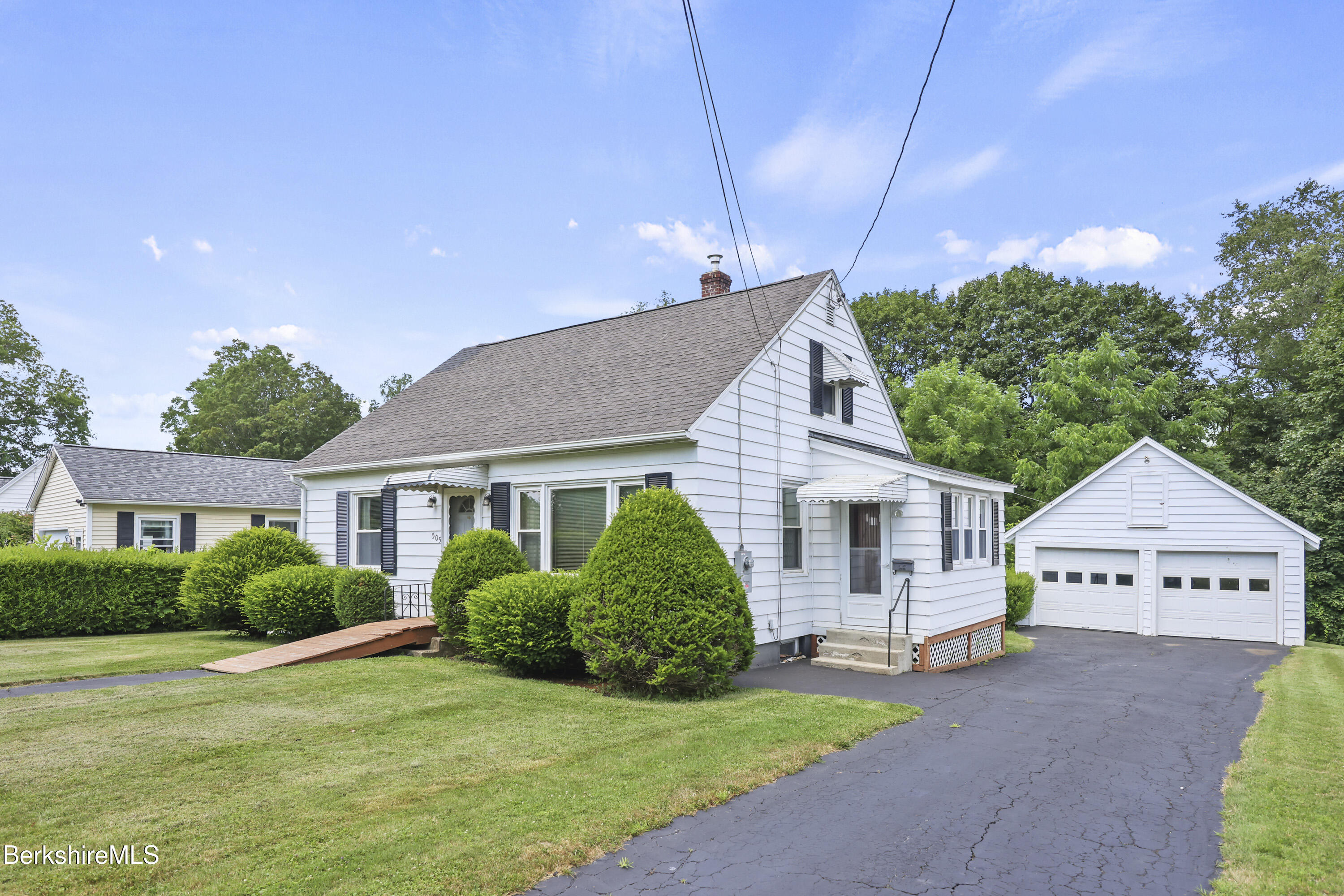 a view of a house with a yard and potted plants