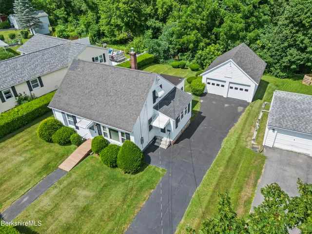 an aerial view of a house with a big yard and large trees