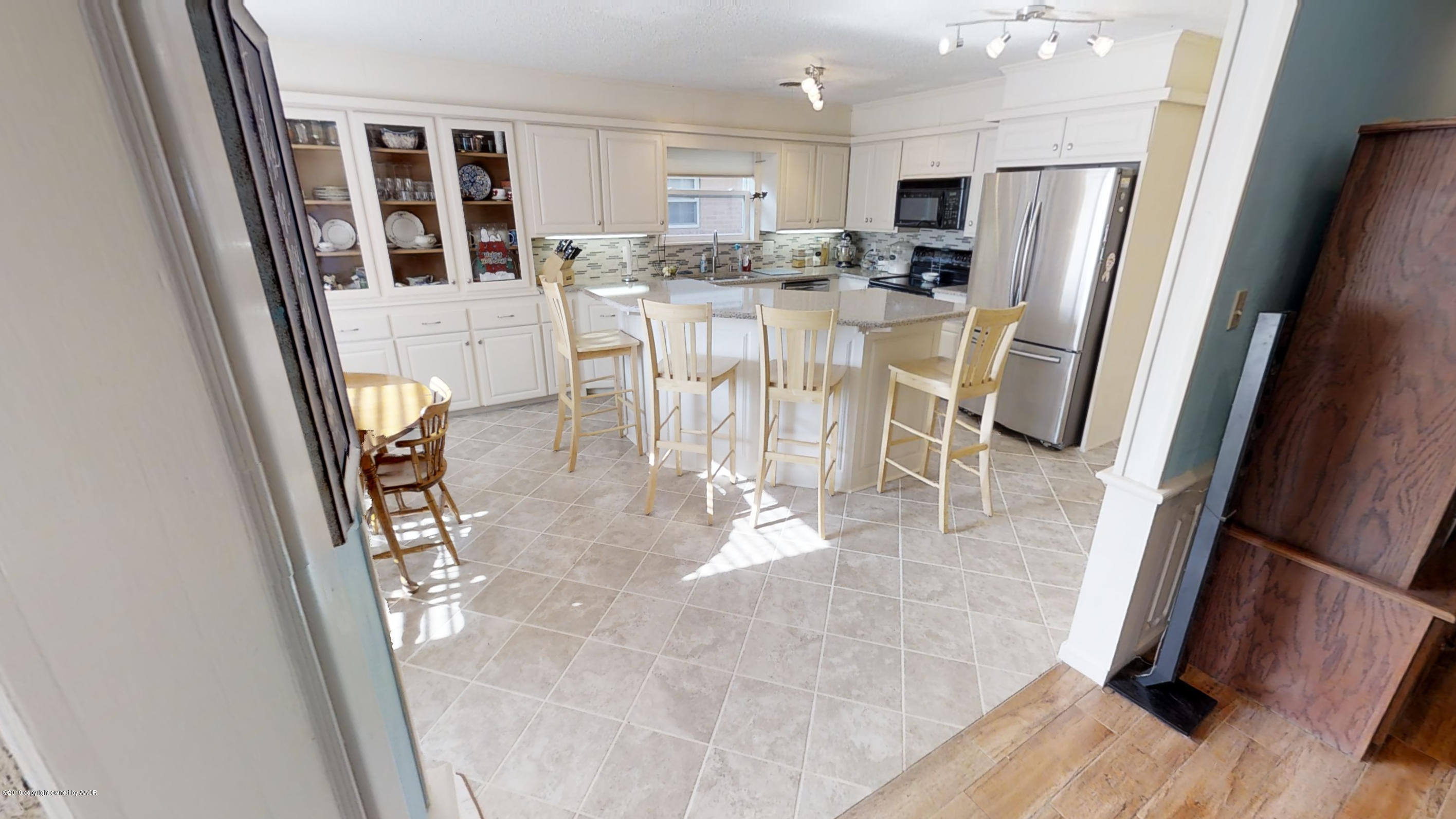 3308 Bedford Road Amarillo, TX 79106 - Photo 2 of 31 a kitchen with stainless steel appliances kitchen island granite countertop a refrigerator a stove a microwave with a dining table and chairs