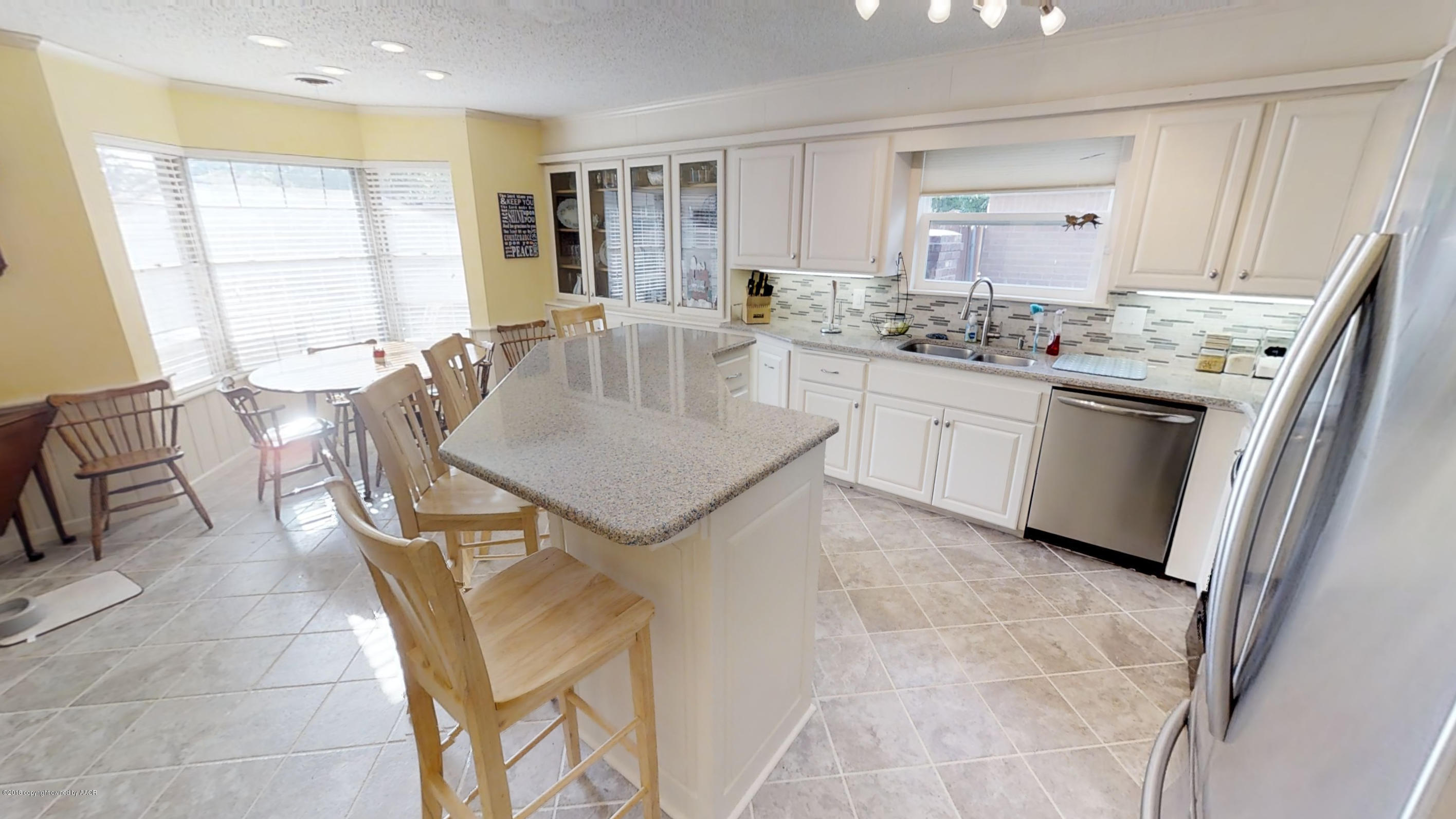 3308 Bedford Road Amarillo, TX 79106 - Photo 10 of 31 a kitchen with kitchen island a stove a sink a table and chair