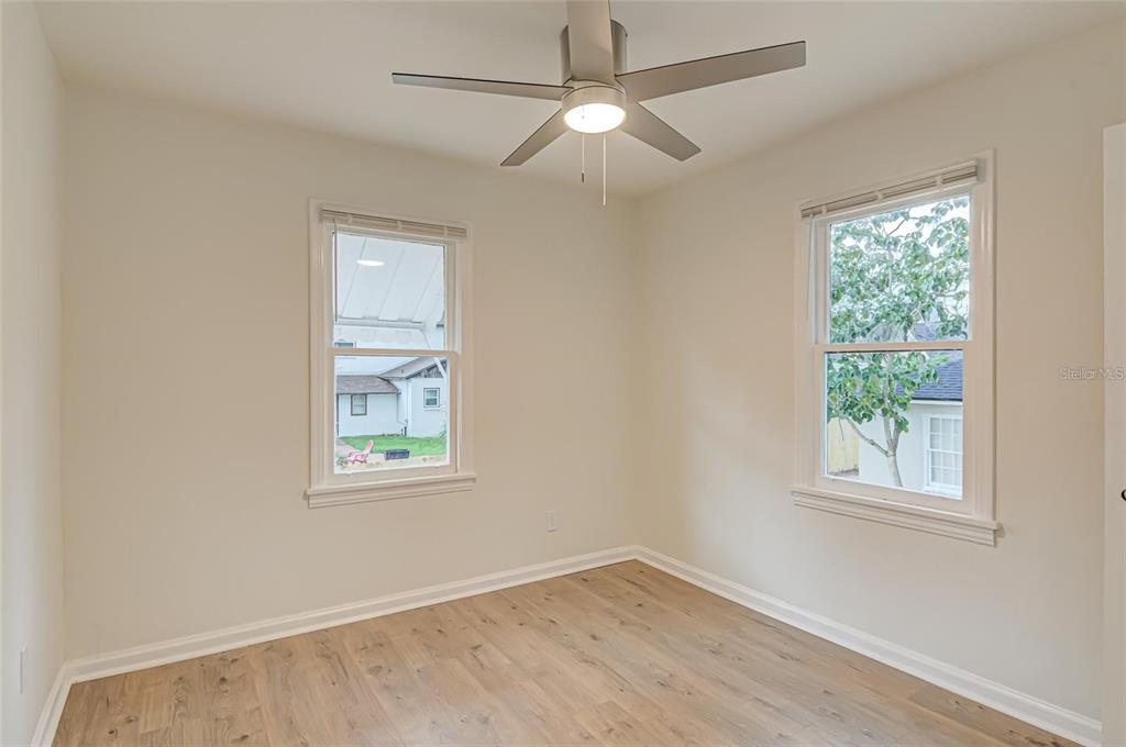 921 Southwest 6th Avenue, Unit B Gainesville, FL 32601 - Photo 12 of 18 an empty room with wooden floor ceiling fan and windows