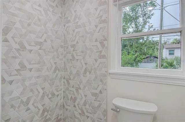 a white toilet sitting next to a window