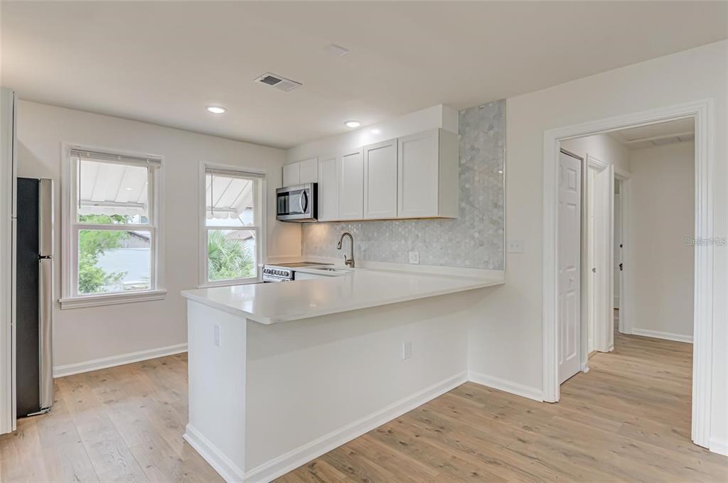 921 Southwest 6th Avenue, Unit B Gainesville, FL 32601 - Photo 18 of 18 a kitchen with stainless steel appliances granite countertop a sink a window and wooden floor