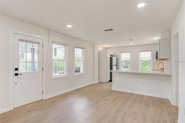 a view of an empty room with a window and wooden floor