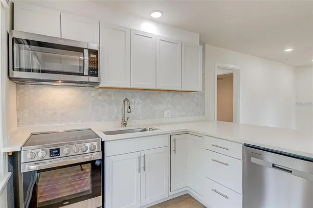 a kitchen with a sink stove and microwave