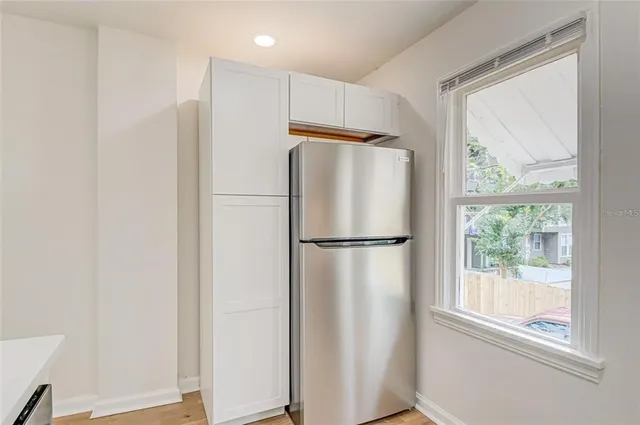 a white refrigerator freezer and a window in a kitchen