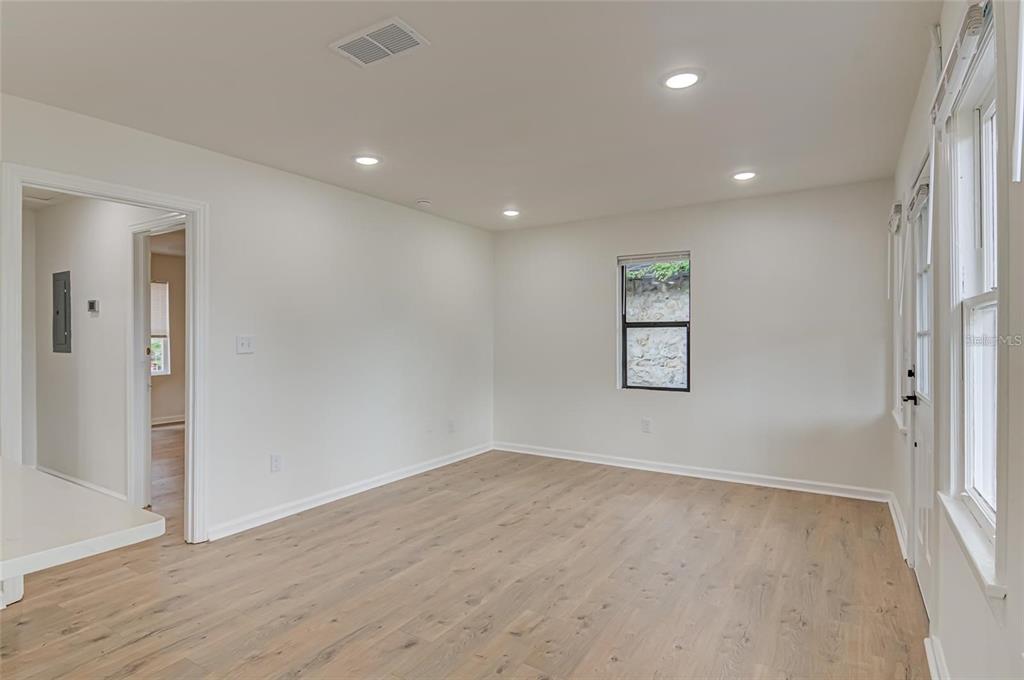 921 Southwest 6th Avenue, Unit B Gainesville, FL 32601 - Photo 8 of 18 an empty room with wooden floor and windows