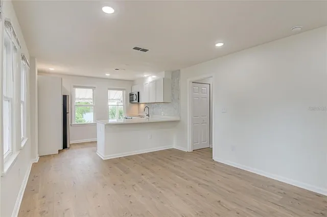 a view of kitchen with wooden floor and electronic appliances