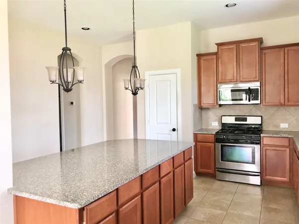 a kitchen with stainless steel appliances granite countertop a sink a stove and cabinets