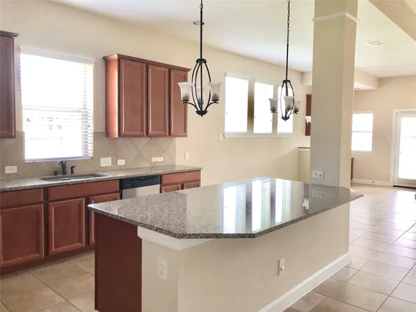 a kitchen with stainless steel appliances granite countertop a sink a stove and a refrigerator