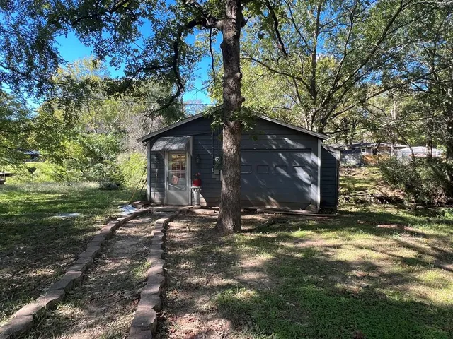 a view of a house with backyard and trees