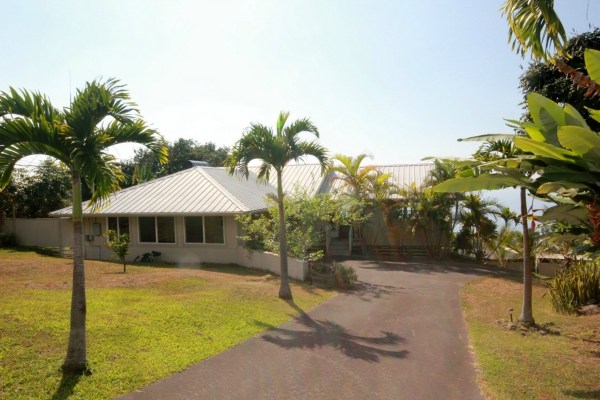 82-1204 Kinue Road Captain Cook, HI 96704 - Photo 3 of 17 a view of a swimming pool with lawn chairs under an umbrella