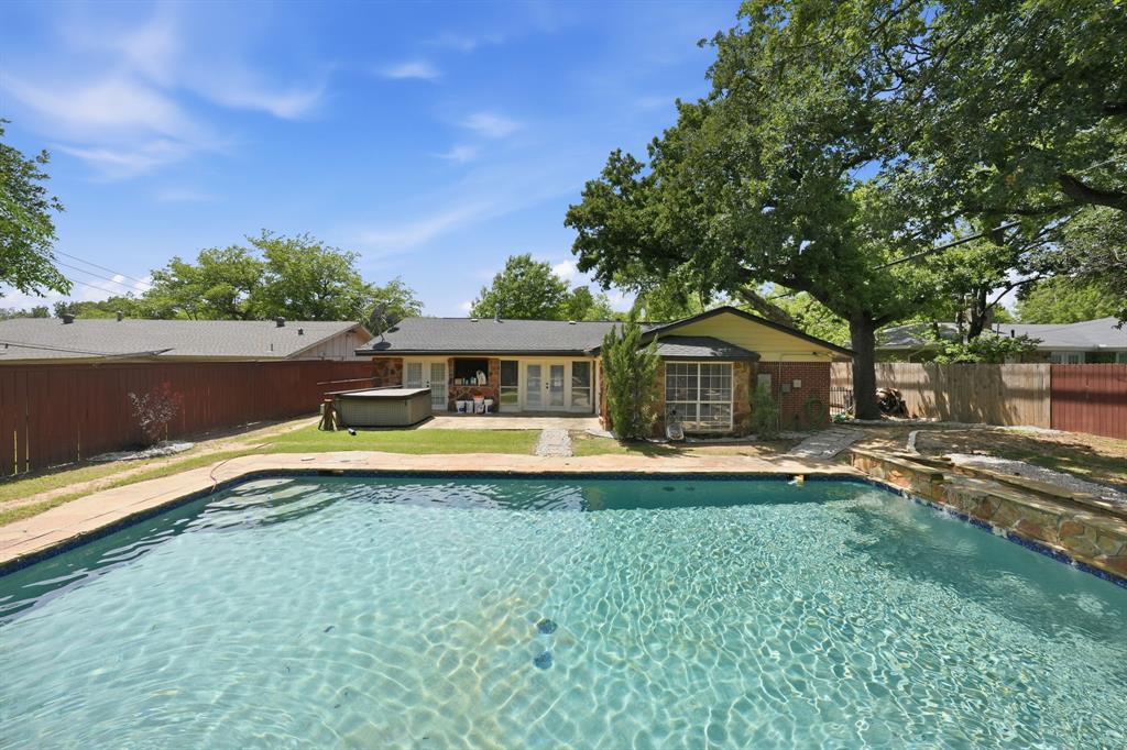 1108 Billie Ruth Lane Hurst, TX 76053 - Photo 27 of 27 Backyard oasis featuring an in-ground swimming pool with stone coping, a large stone patio, and mature trees providing natural shade