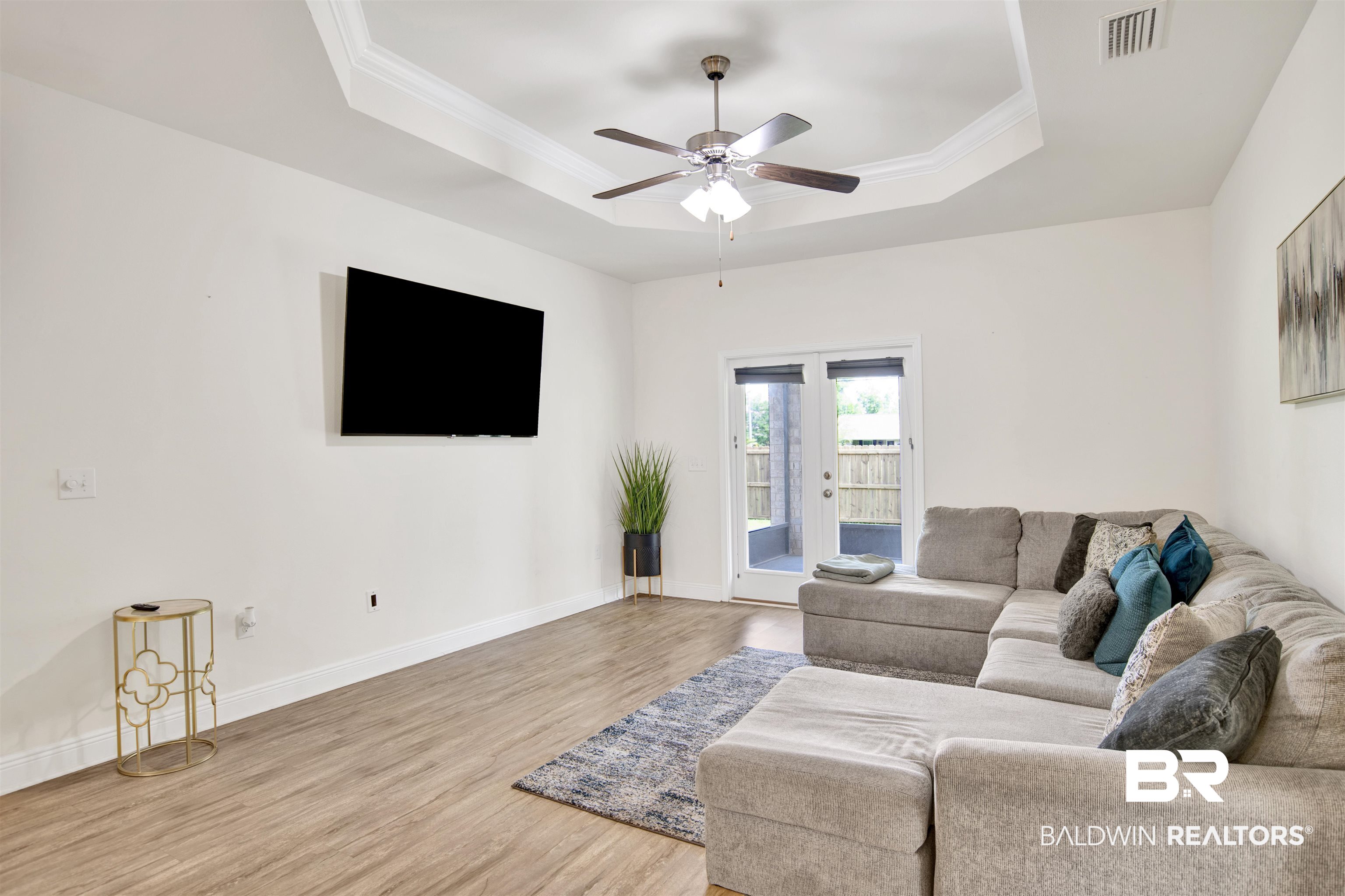 1468 Surrey Loop Foley, AL 36535 - Photo 14 of 28 Living area with a raised ceiling, wood finished floors, ceiling fan, crown molding, and baseboards