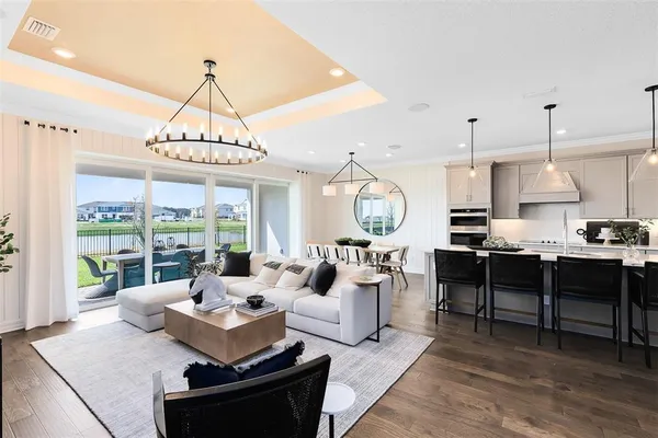 a living room with furniture a dining table and a chandelier