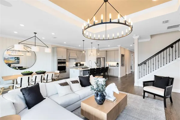 a living room with furniture a dining table and a chandelier