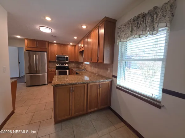 a kitchen with stainless steel appliances a refrigerator and a stove top oven